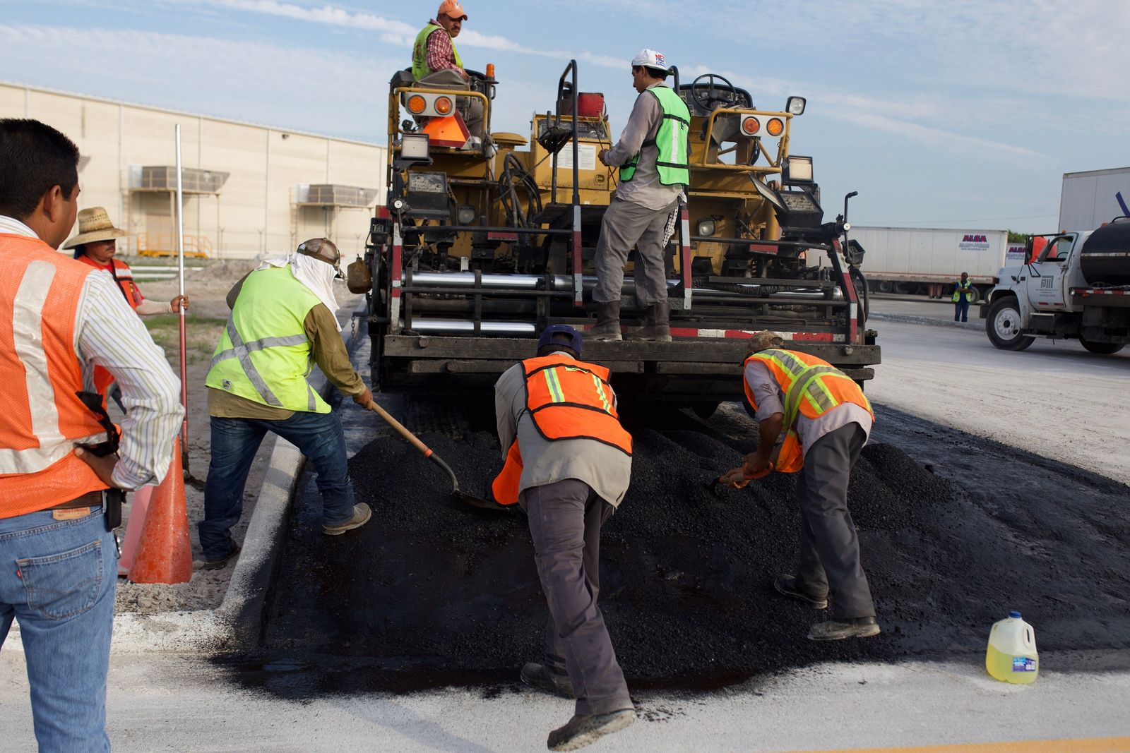 Commercial paving crew laying asphalt on an active job site